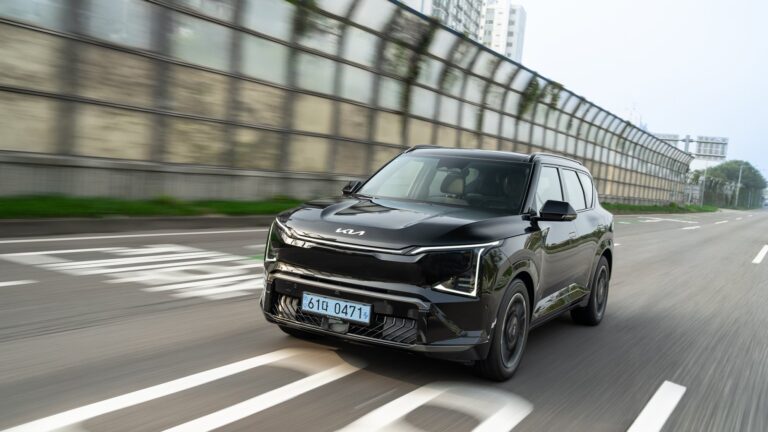 Kia vontatás és tetőterhelés: fekete Kia EV5 tetősínnel az autópályán