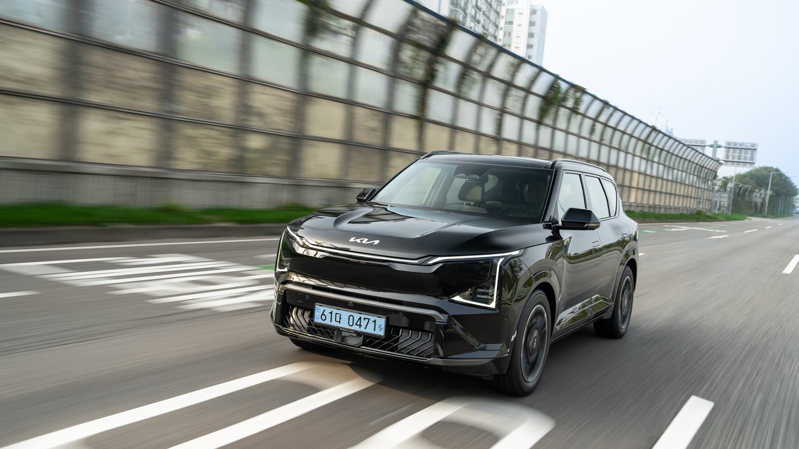 Kia vontatás és tetőterhelés: fekete Kia EV5 tetősínnel az autópályán